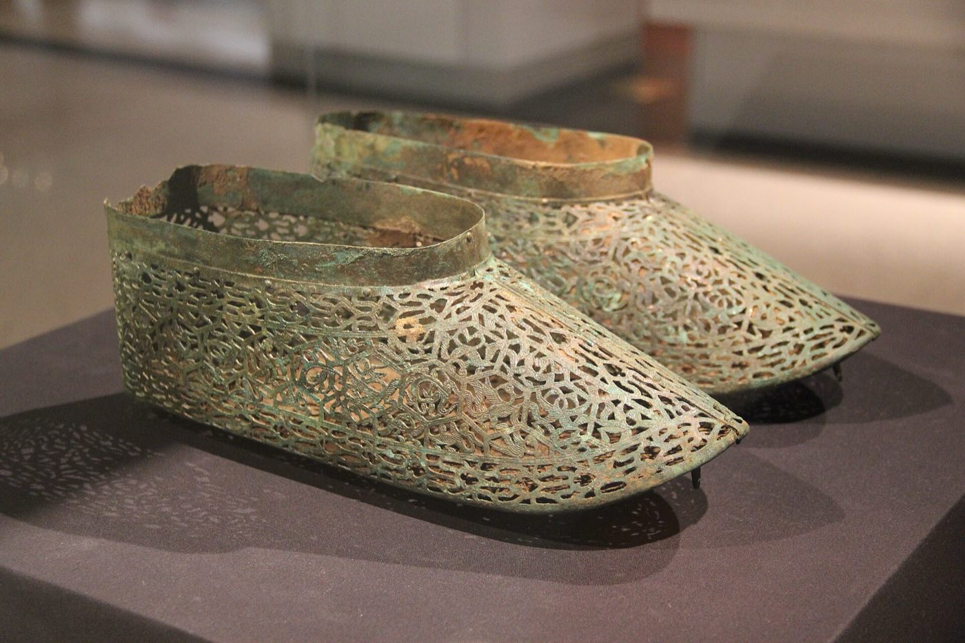 Gilt-bronze shoes with openwork sides in the Baekje gallery of the National Museum of Korea. Too fragile for walking, shoes like these were made for burial and were placed on the feet of local rulers along with gilt-bronze caps.