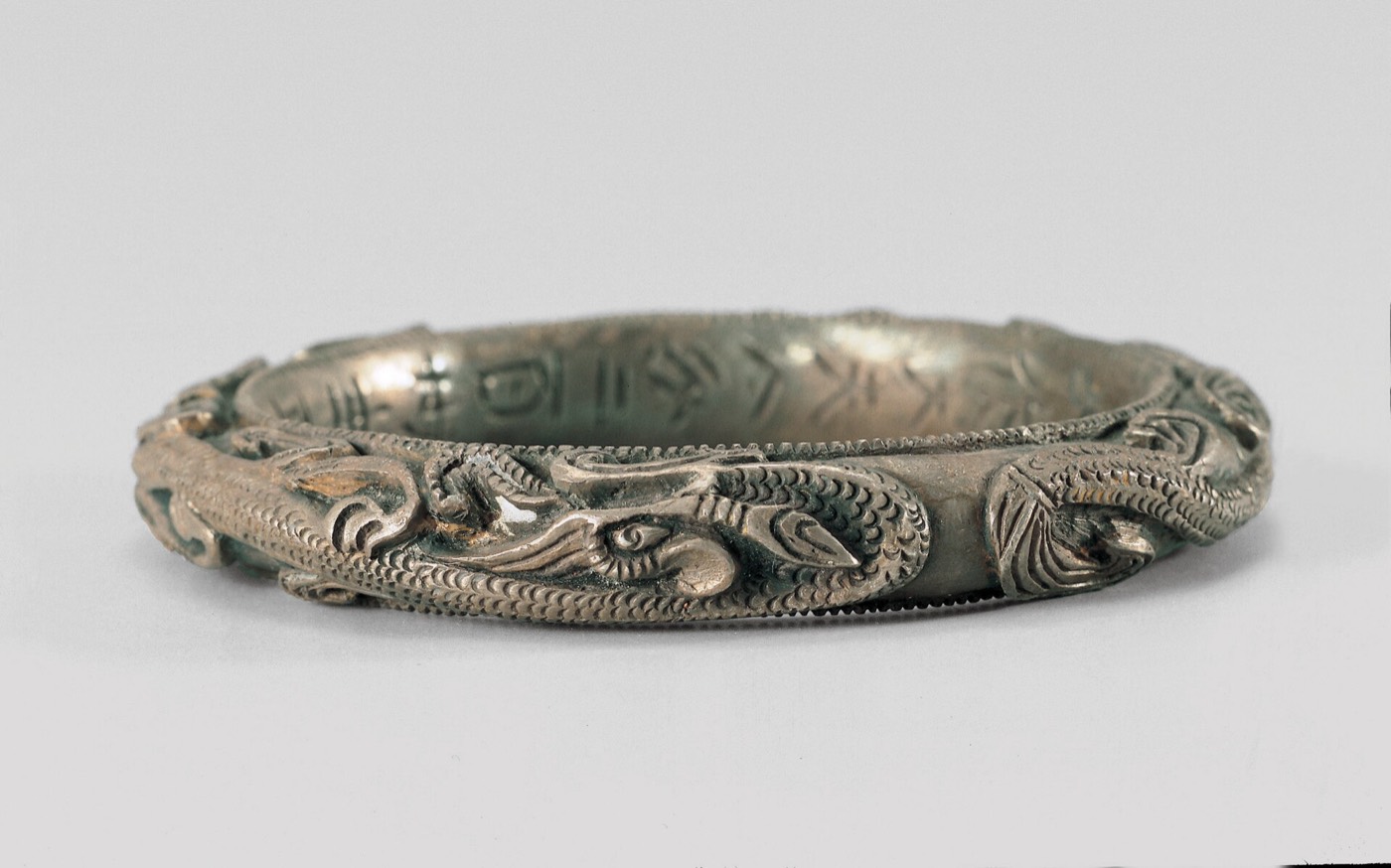 Pair of silver bracelets from the queen’s side of the tomb of King Muryeong, carved with dragons. An inscription says they were made in the gyeongja year (520) by a craftsman named Dari for the queen, one of the few signed works of Baekje.