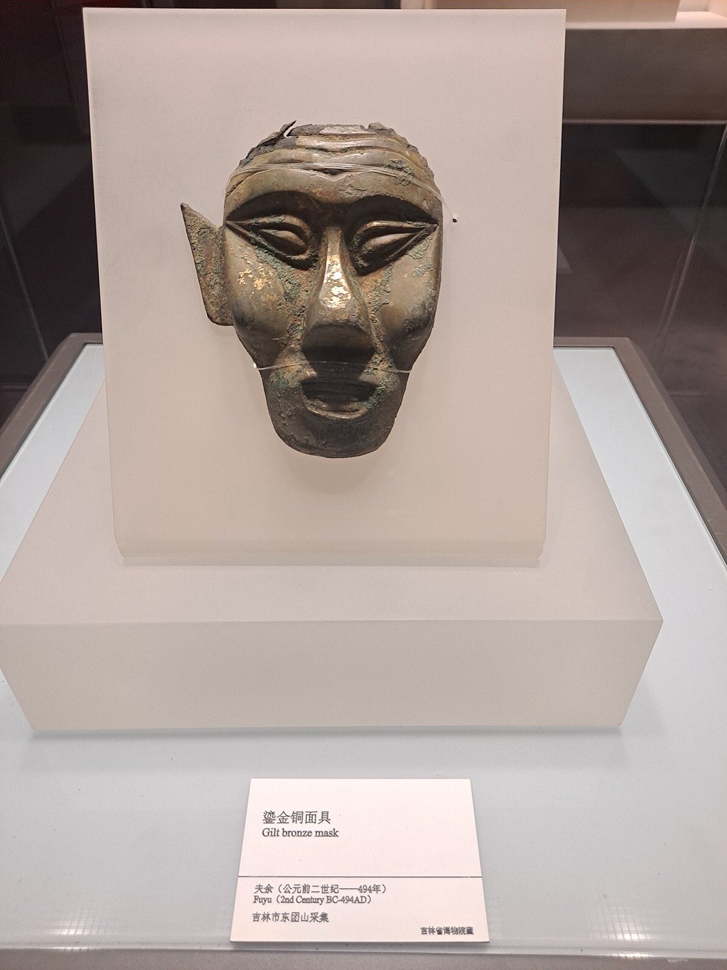 Small gilt-bronze mask of a human face collected at Dongtuanshan in Jilin City, the old heartland of Buyeo. How it was worn or used is still uncertain.
