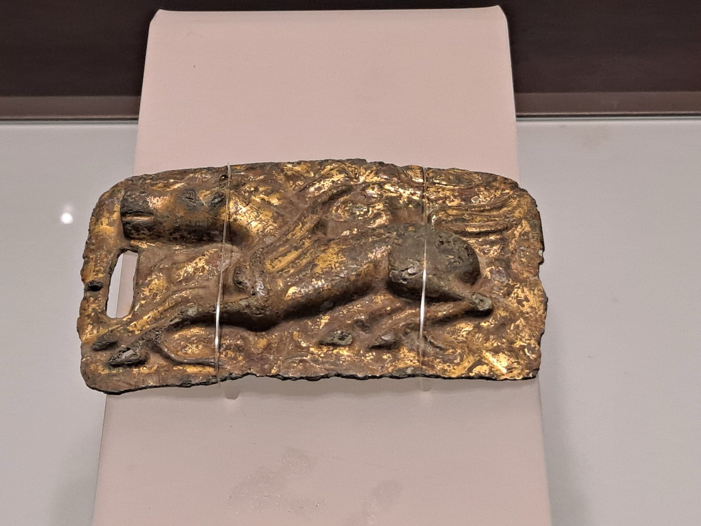 Gilt-bronze plaque decorated with a mythical beast in relief, from the Buyeo collection of the Jilin Provincial Museum. Animal-style plaques like this belong to the steppe tradition of belt ornaments shared across northeast Asia.