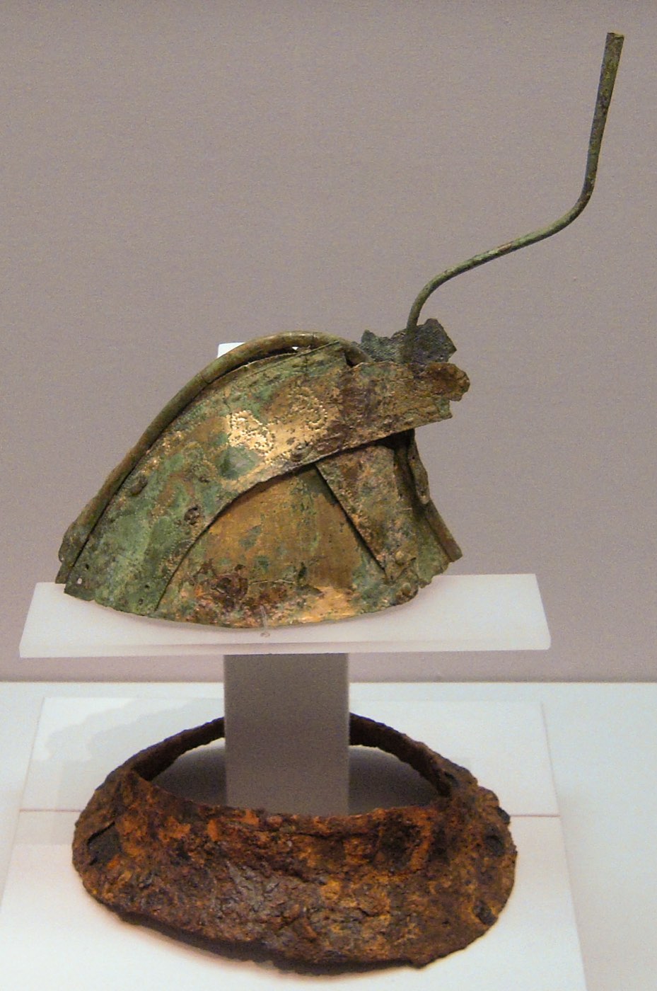 Helmet with a crest and plume holder from Hapcheon, displayed with an iron neck guard in the National Museum of Korea. The tall rod at the top held a plume.