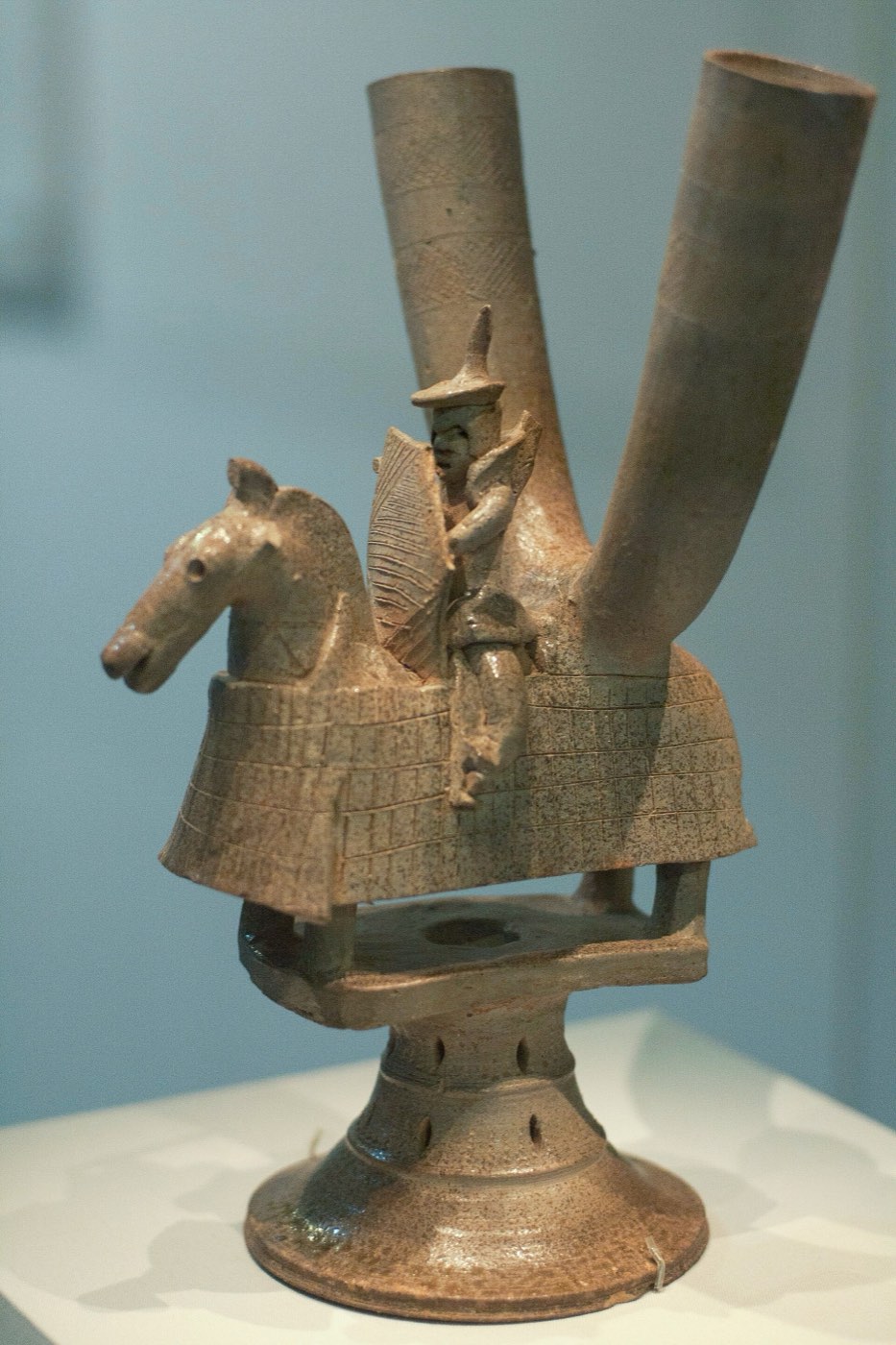 Stoneware vessel with two horn cups behind a mounted warrior, reportedly from Deoksan-ri, Gimhae. The rider holds a shield and spear, and his horse wears armour, a small-scale picture of Gaya armoured cavalry.