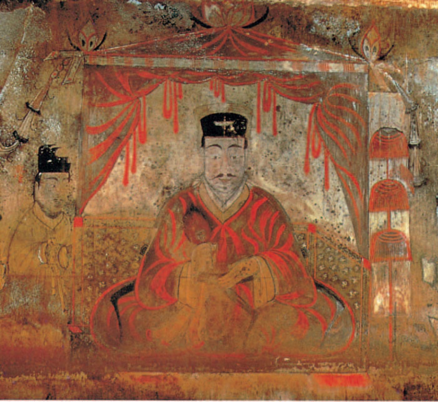 The tomb owner of Anak Tomb No. 3 sits frontally under a canopy, flanked by officials. He wears a tall court cap and a red robe, the formal dress of a ruler receiving his court.