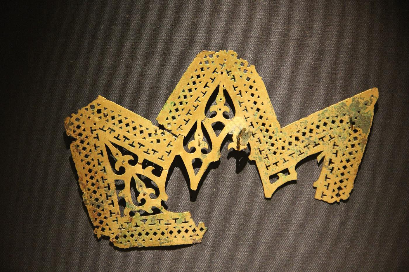Fragments of a Goguryeo gilt-bronze crown in the National Museum of Korea, the band pierced in a flame pattern. Goguryeo crowns are much rarer than Silla ones; murals suggest the elite more often wore cloth or lacquered caps.