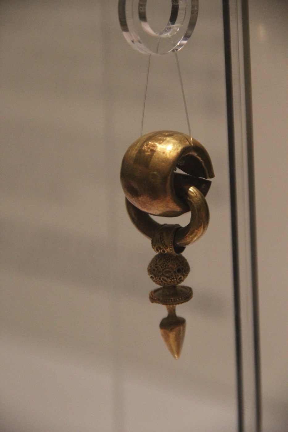 Gold earring in the Goguryeo gallery of the National Museum of Korea: a thick hollow ring with a spherical spacer and a pointed pendant. Goguryeo earrings are fewer and plainer than those of Silla and Baekje.