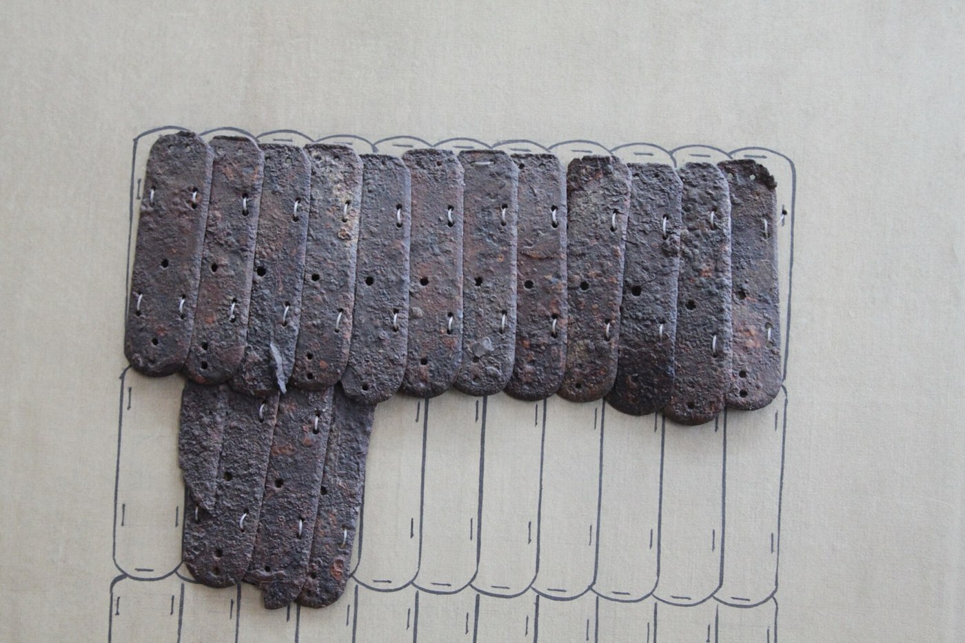 Small iron plates (lamellae) from Jilin, labelled as Goguryeo, with holes for the laces that joined hundreds of them into a flexible coat. This is the lamellar armour worn by the soldiers in the murals.