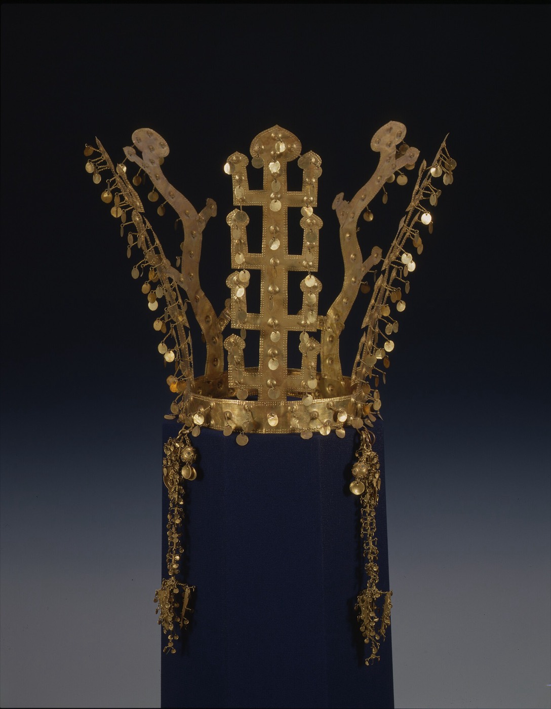 Small gold crown from Geumnyeongchong (the Gold Bell Tomb) in Gyeongju. Its tree-shaped uprights have four tiers instead of the usual three, and they carry only gold spangles with no jade, so it looks plainer than other Silla crowns.