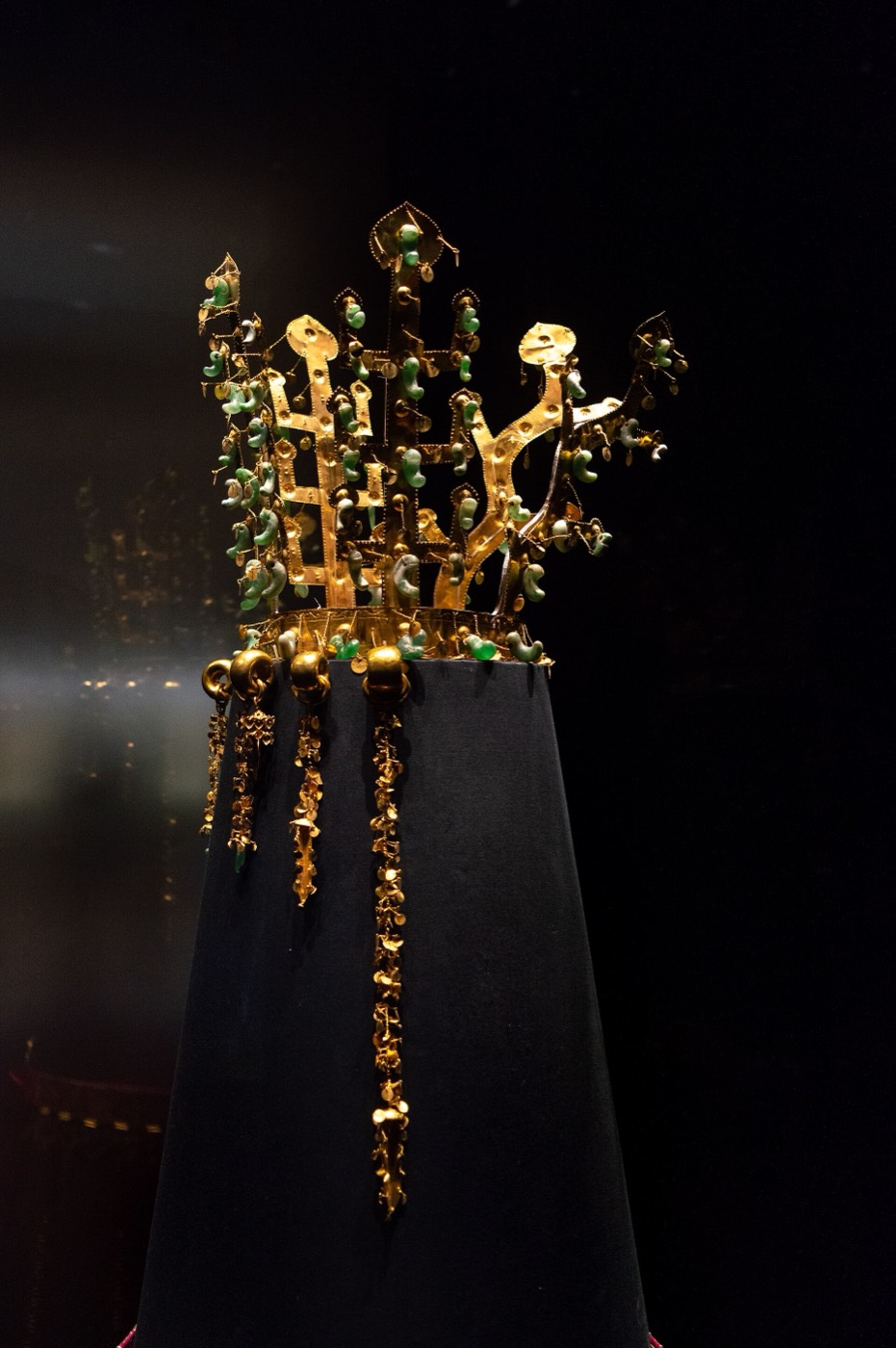 Gold crown from the north mound of Hwangnam Daechong in Gyeongju, the burial of a high-ranking woman, probably a queen. Three tree-shaped and two antler-shaped uprights rise from the band, hung with jade comma beads and gold spangles, and long pendants fall beside the face.