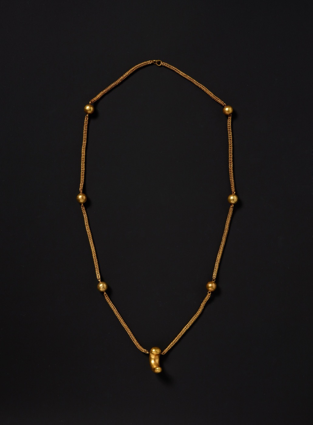 Gold necklace from the south mound of Hwangnam Daechong, a fine chain with hollow gold beads spaced along it and a pendant at the centre.
