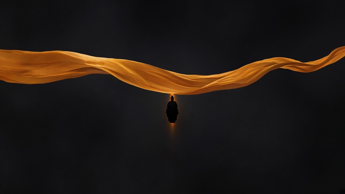 High hem-ribbon of amber silk across the upper third; tiny standing silhouette hanging from it — no kowtow